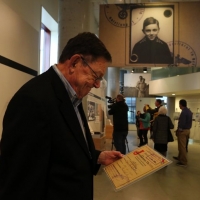 Steve at the opening of the Holocaust Center, with the photo of him as a child in the background. October 2015.
